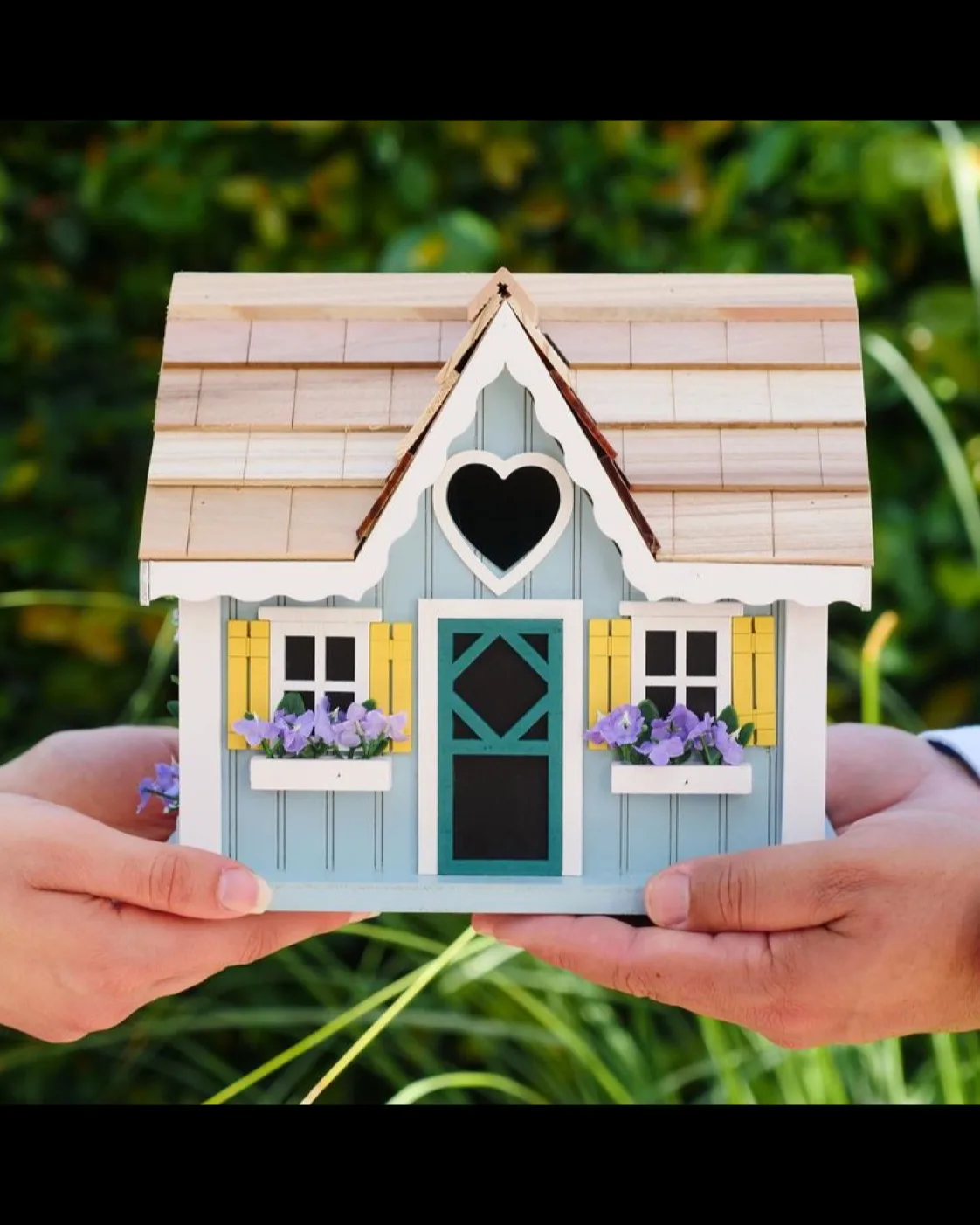 Deux mains tenant une maison miniature